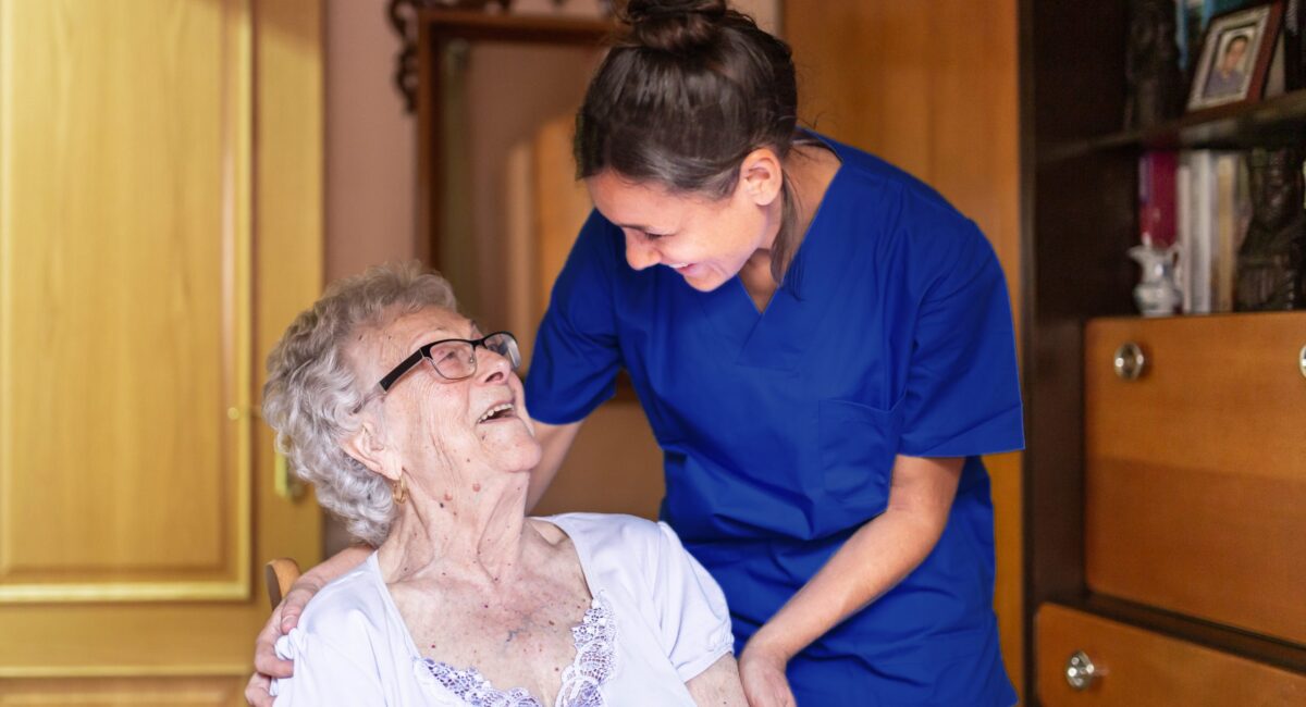 Happy Senior woman laughing with her caregiver at home. Senior
