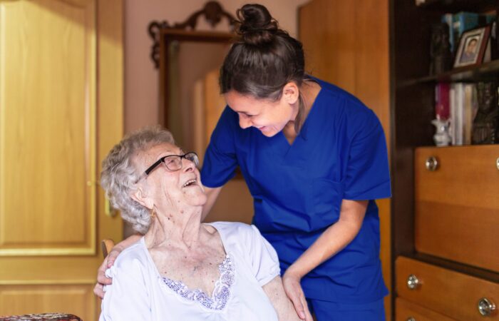 Happy Senior woman laughing with her caregiver at home. Senior